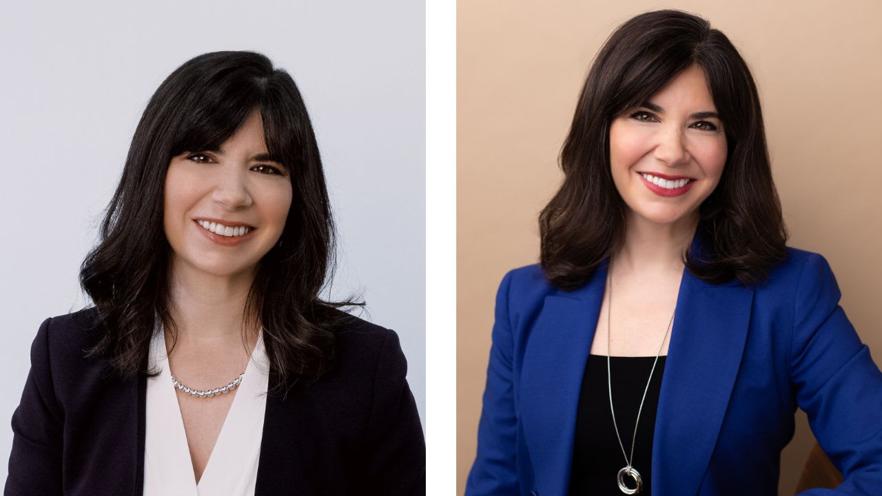 Two women with shoulder-length dark hair wearing business attire, each smiling at the camera; one in a dark blazer on the left and one in a blue blazer on the right.